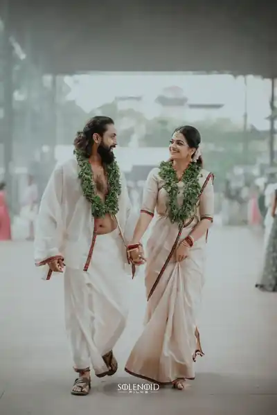 Traditional Kerala couple walking hand in hand, garlanded
